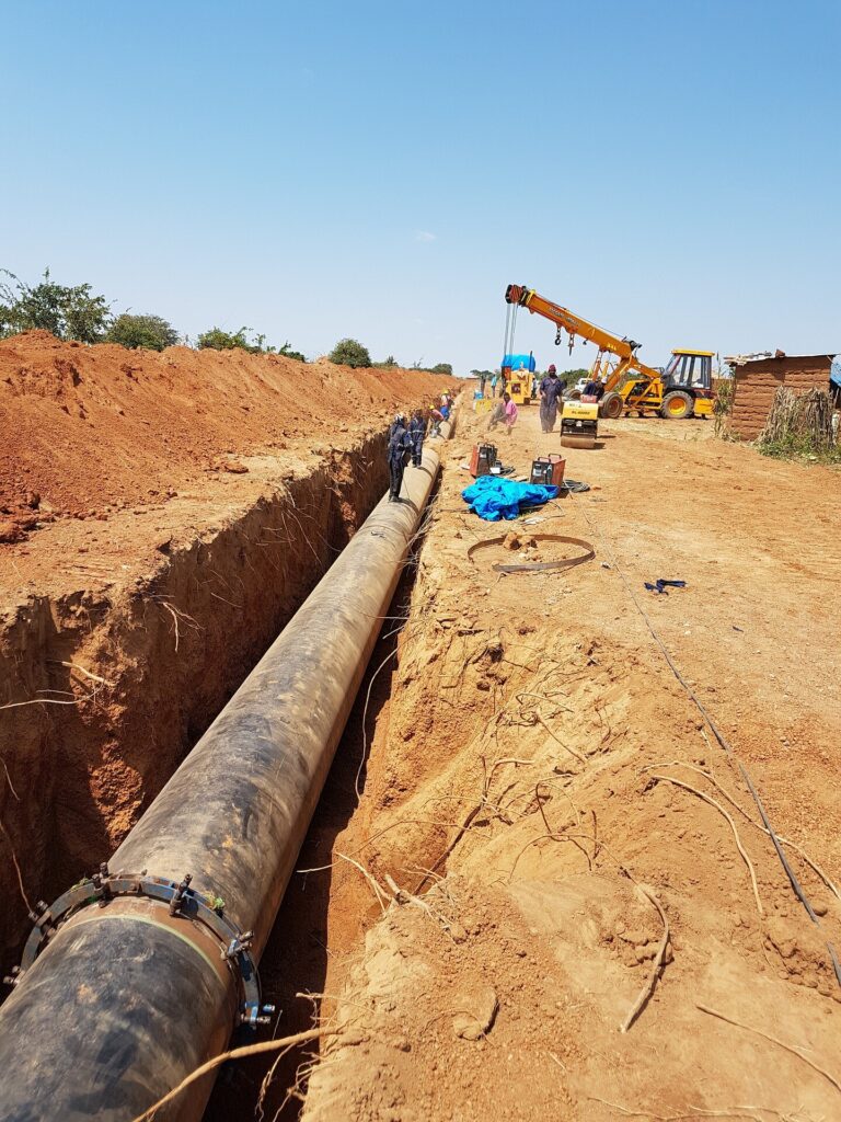 Large pipeline project, with pipe in trench waiting to be backfilled.