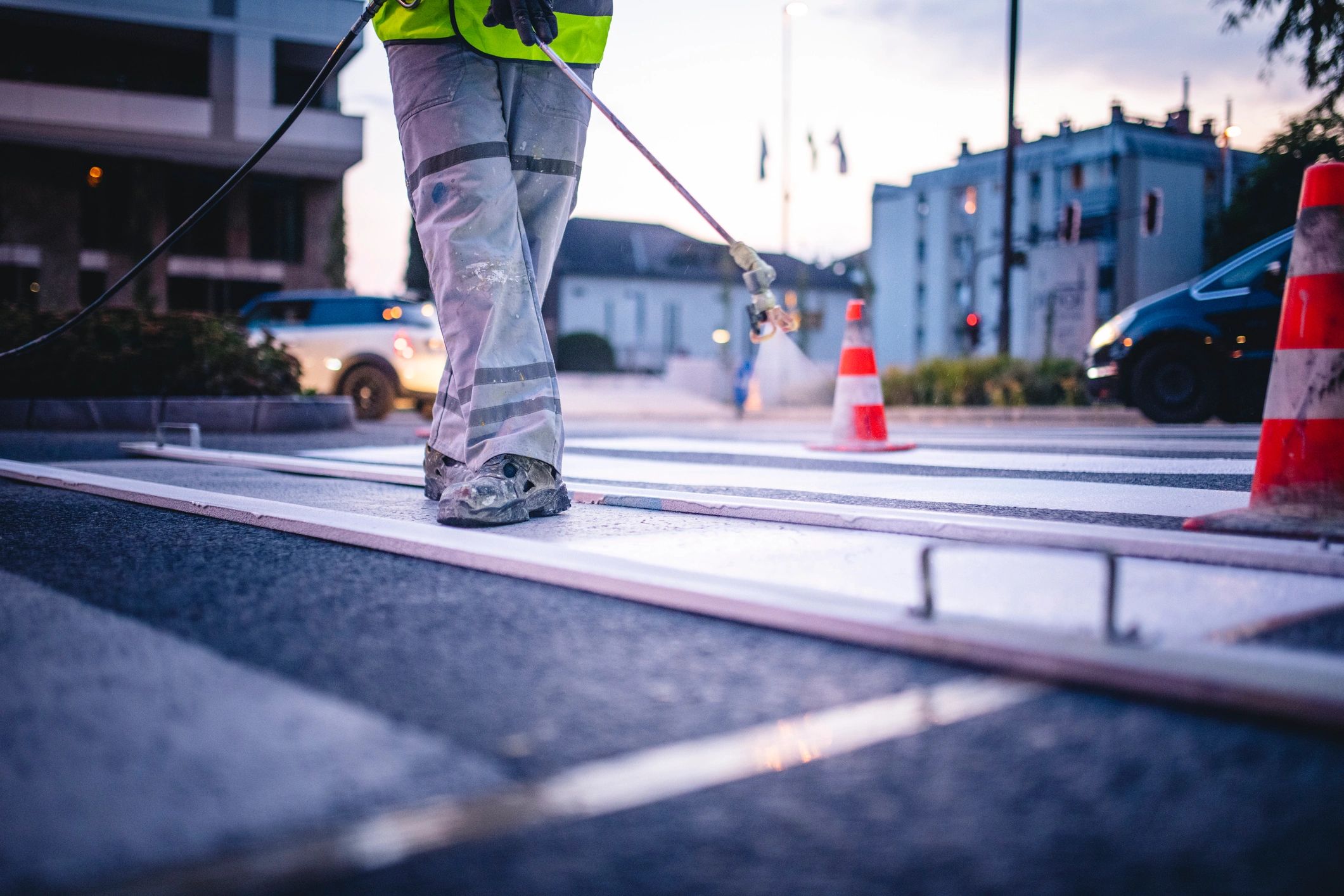 Worker spray painting markings on a street surface