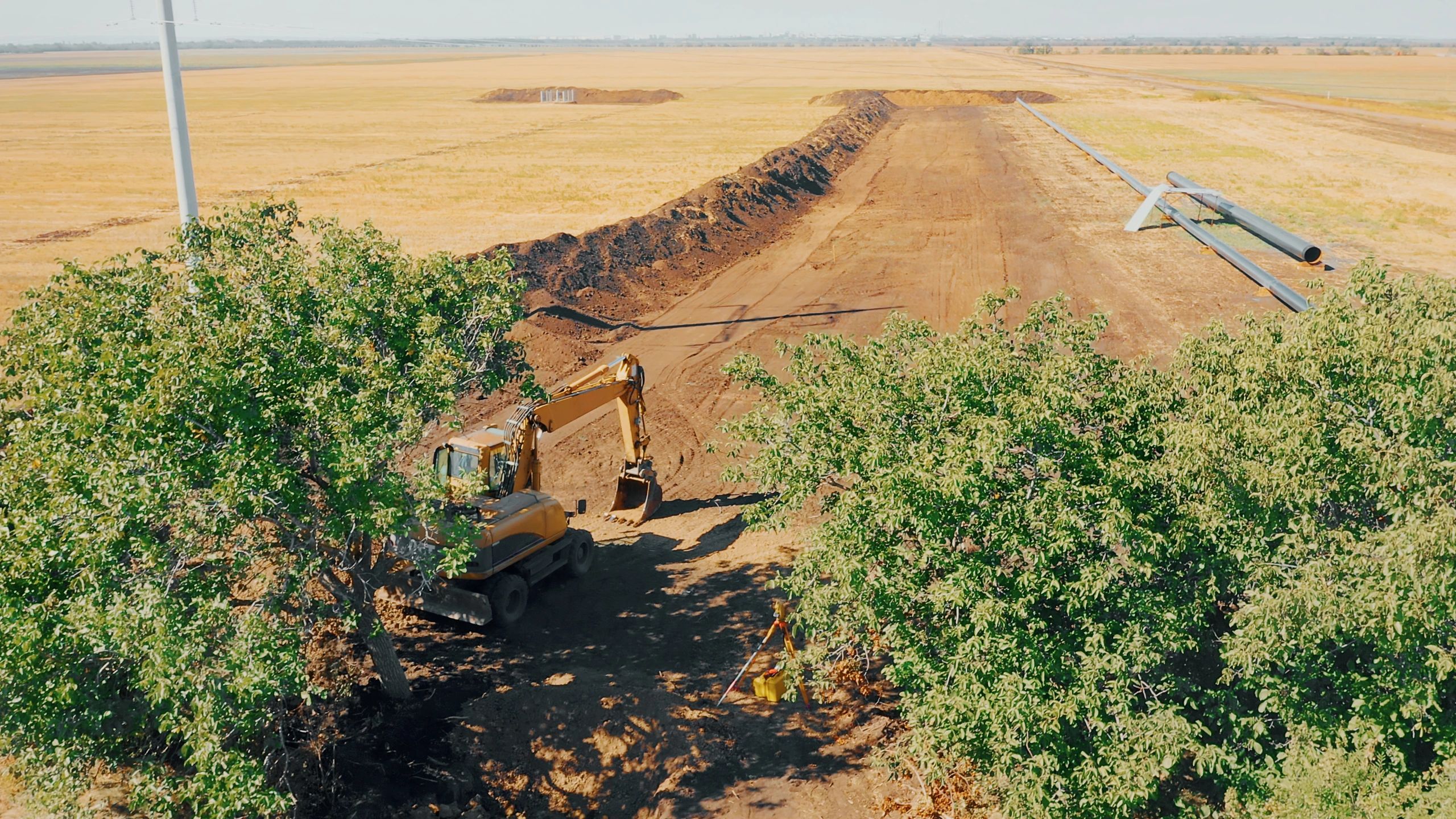 Excavator trenching at a pipeline construction site